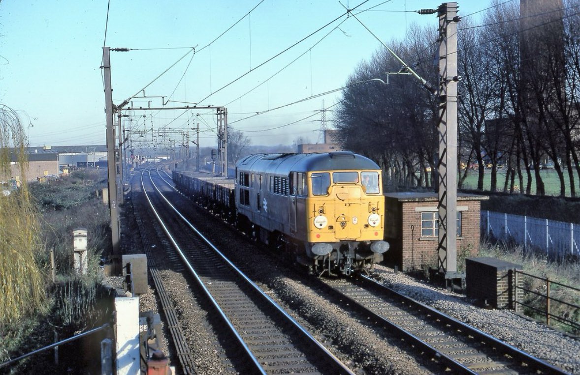 31015 approaches Broxbourne Junction signal box with the 12:45 Hertford East to Temple Mills freight consisting of concrete sleepers from Costain at Rye House, 3rd December 1979. 

📸 Michael Hart