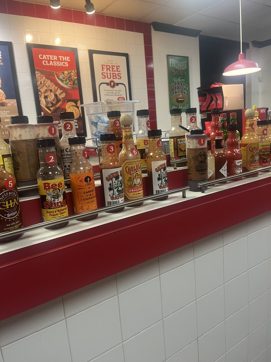 Moomin3371's tweet photo. Fire House Subsはサンドイッチのチェーン店。
消防署のイメージを取り入れた内装が特徴。
最初これを見た時消防士のお客さんがいて制服を掛けてるのかと思いました。
消防士の家族をサポートする慈善活動を行っています
Fireだけあって辛いホットソース🥵がズラリ
#アメリカ生活 #Firehousesubs https://t.co/NZSma1IBKv