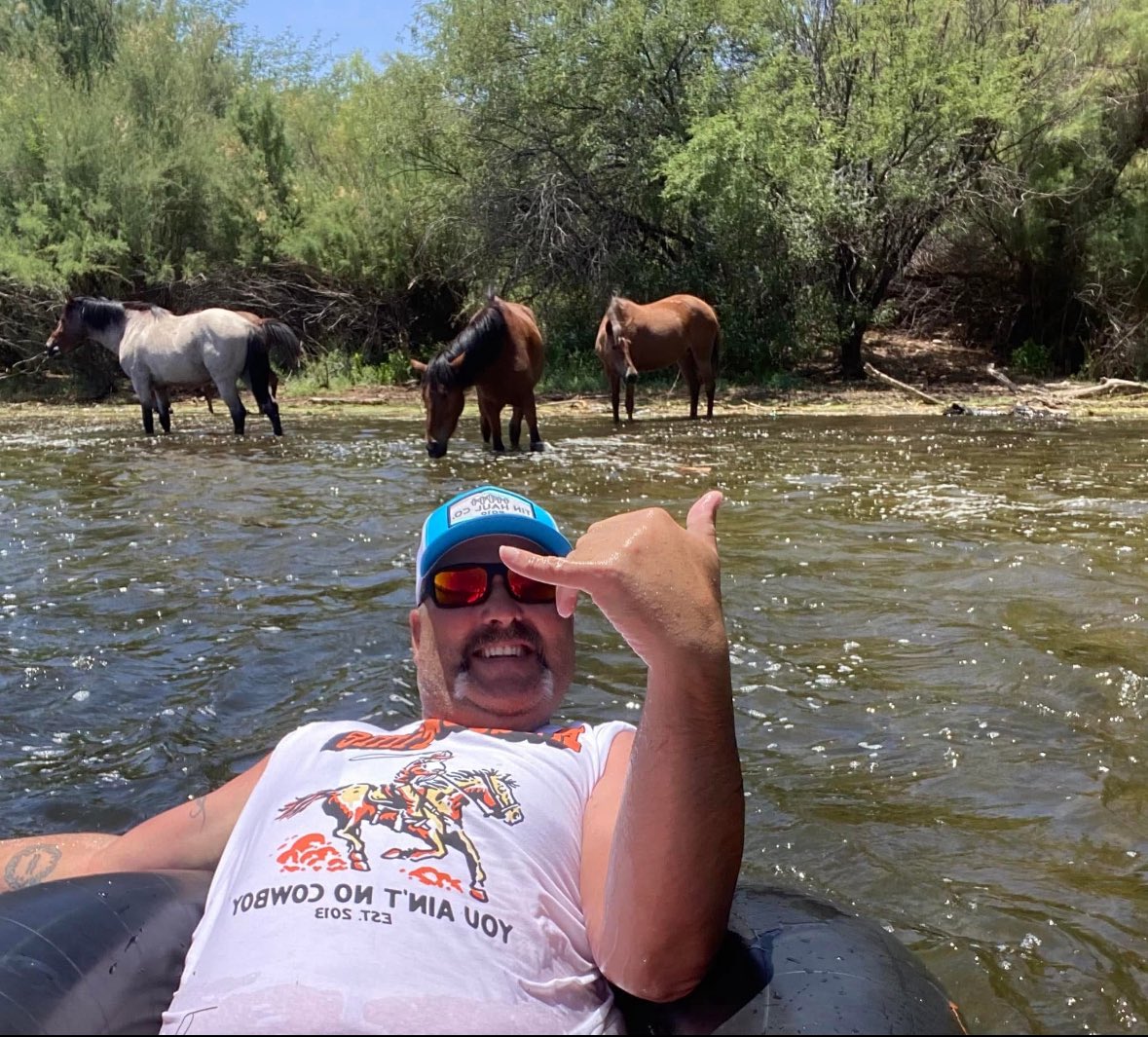 MC_Sears's tweet photo. @dalebrisby here’s a pic of me on vacay in AZ reppin’ #rodeotime #youaintnocowboy gear while floating the Salt River with wild horses behind me! https://t.co/jgngonhlMn