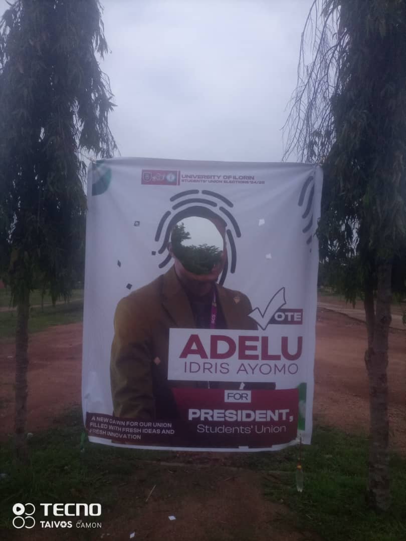 Plutoflagos2's tweet photo. They tore Adelu’s banner, but not his ability.  
You can’t shred A New Dawn. 
Fresh ideas, fresh innovations, that’s what scares them.  
We rise above hate. We stand with Adelu. @AdelumolaJnr
@UCJ_UNILORIN
#ADELUFORSUPRESIDENT
#WeStandWithAdelu   
#Unilorindecides25 https://t.co/yQzL1zn7wy