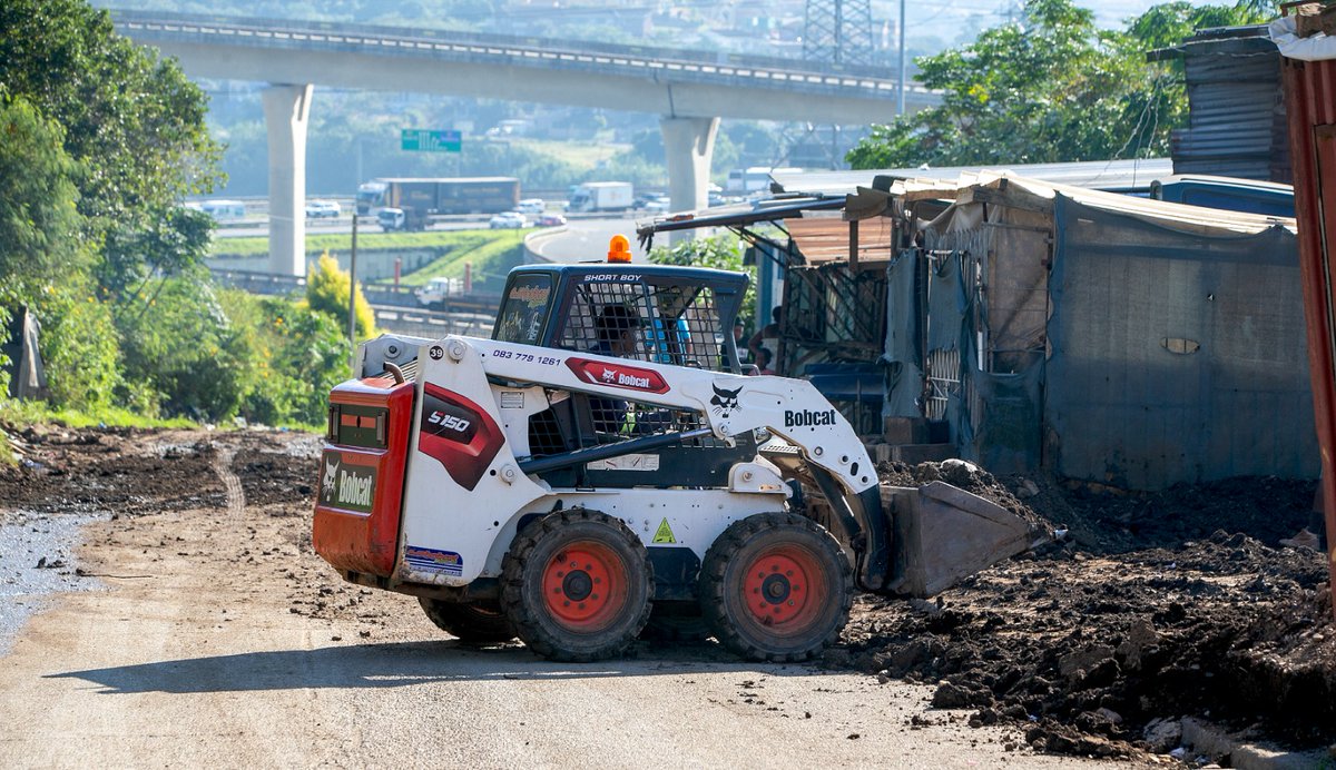 TheMercurySA's tweet image. South Africa - Durban - Transport operators frustrated with the poor state of Kennedy Road in Clare Estate hired a grader to fill in potholes and make the road drivable. 
Photographer: Leon Lestrade / Independent Newspapers
#transportoperator #frustration #KennedyRoad #themercury