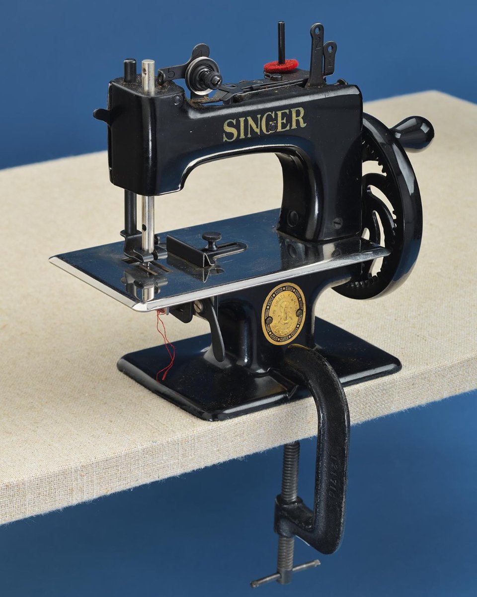 Happy #NationalSewingMachineDay! Elias Howe did not invent the sewing machine, but he was granted the first sewing machine-related US patent in 1846. This 1954 Singer sewing machine toy from our collection attaches to a table and is operated by turning a hand crank on the side.