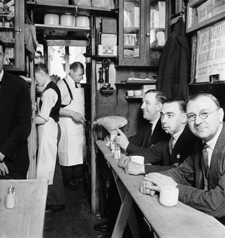 London taxi drivers in suits relax inside a taxi cab shelter at Piccadilly. London, 1934.