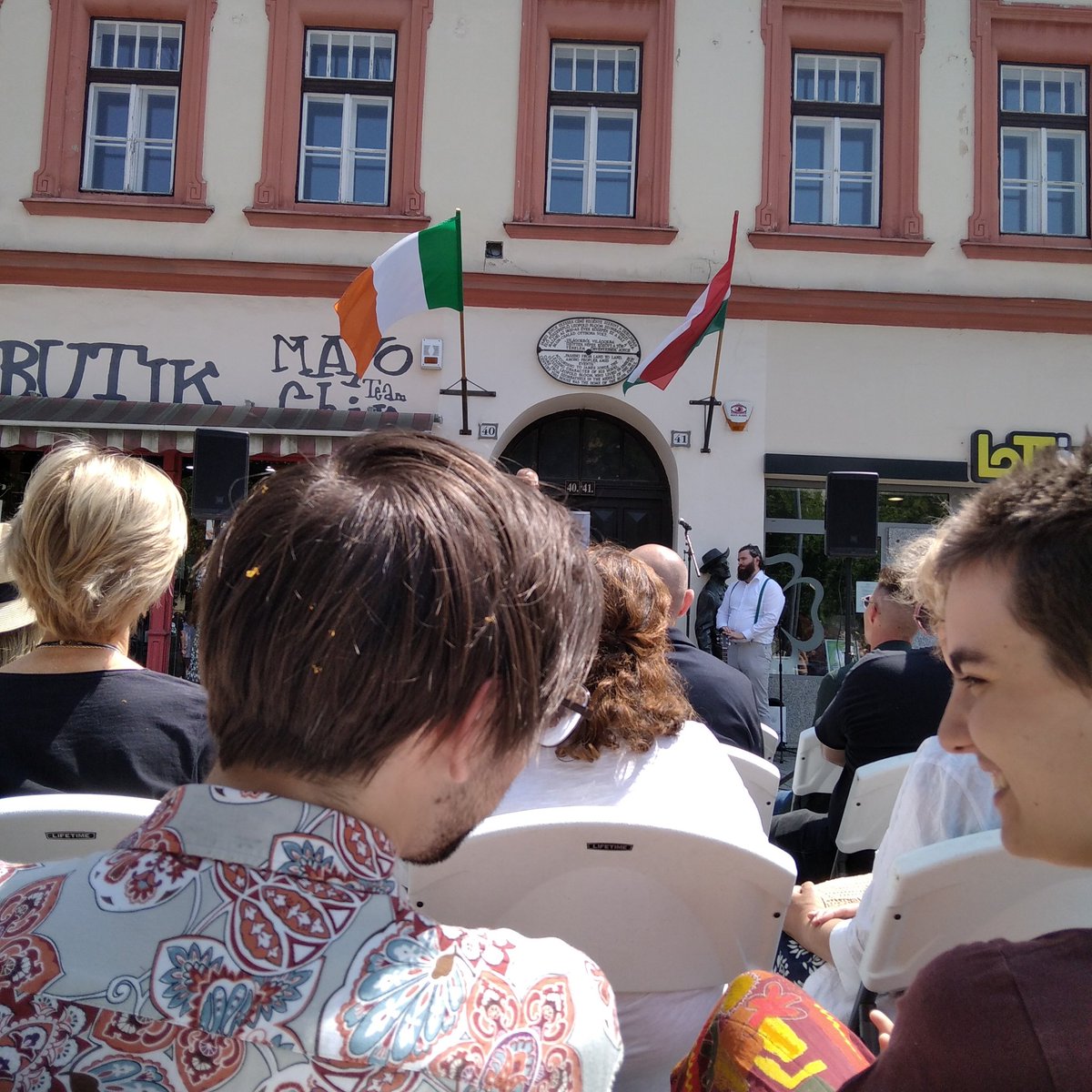 any54's tweet image. Bloomsday. 1. Dr. Nemény feje búbja esetleg, a két zászló között, mert a tűző naptól semmit sem lehetett látni. 2. Ragnar Almqvist ír nagykövet. 3. Pecsételés, porcukorszórással. 4. Én örülök, hogy elmentünk, ott voltunk.