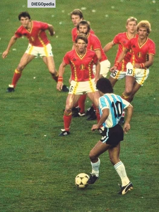 pierpi13's tweet photo. 13 giugno 1982 Camp Nou di Barcellona. D10s resta immortale in uno scatto fotografico del fotografo americano Steve Powell: Maradona compare di spalle, in primo piano con il suo riconoscibile numero 10, mentre sei giocatori del Belgio davanti a lui sembrano prepararsi a difendere un suo attacco. Nessuna istantanea nella storia del calcio ha rappresentato meglio il terrore assoluto degli avversari, all’idea di dover affrontare; l'unico giocatore in grado di cambiare da solo le sorti di una partita.
