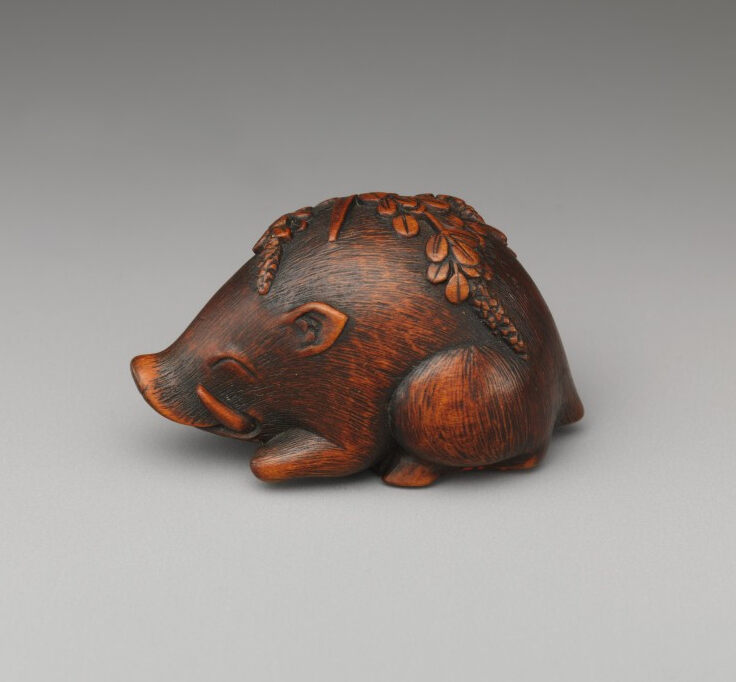 Netsuke figure depicting a sleeping boar covered with grasses, carved from wood, Meiji period (1868–1912 AD). Collection: The Metropolitan Museum of Art.