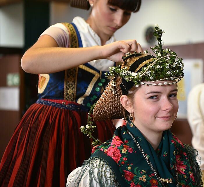 Girl having her hair styled as part of the Ochsenfurt folk clothing, Unterfranken, Germany.