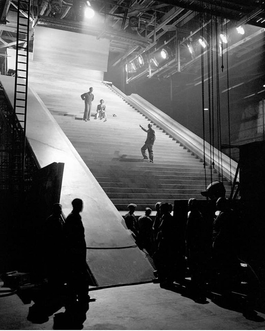 Michael Powell directs David Niven and Kim Hunter on the 'stairway to heaven' in 1946's "A Matter of Life and Death." The escalator took engineers 3 months to build with 106 steps 20 feet wide. A 12 hp engine ran the escalator, costing nearly $200,000 in today's US dollars.