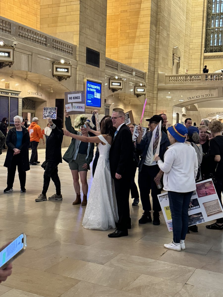 Newlyweds taking pictures with No Kings Day protesters at Grand Central.