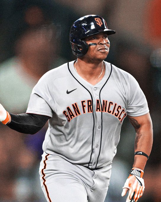 A jersey swap of Rafael Devers in a road gray San Francisco Giants uniform with black lettering, orange trim, and a black helmet. He is shown standing and looking out after hitting a home run.