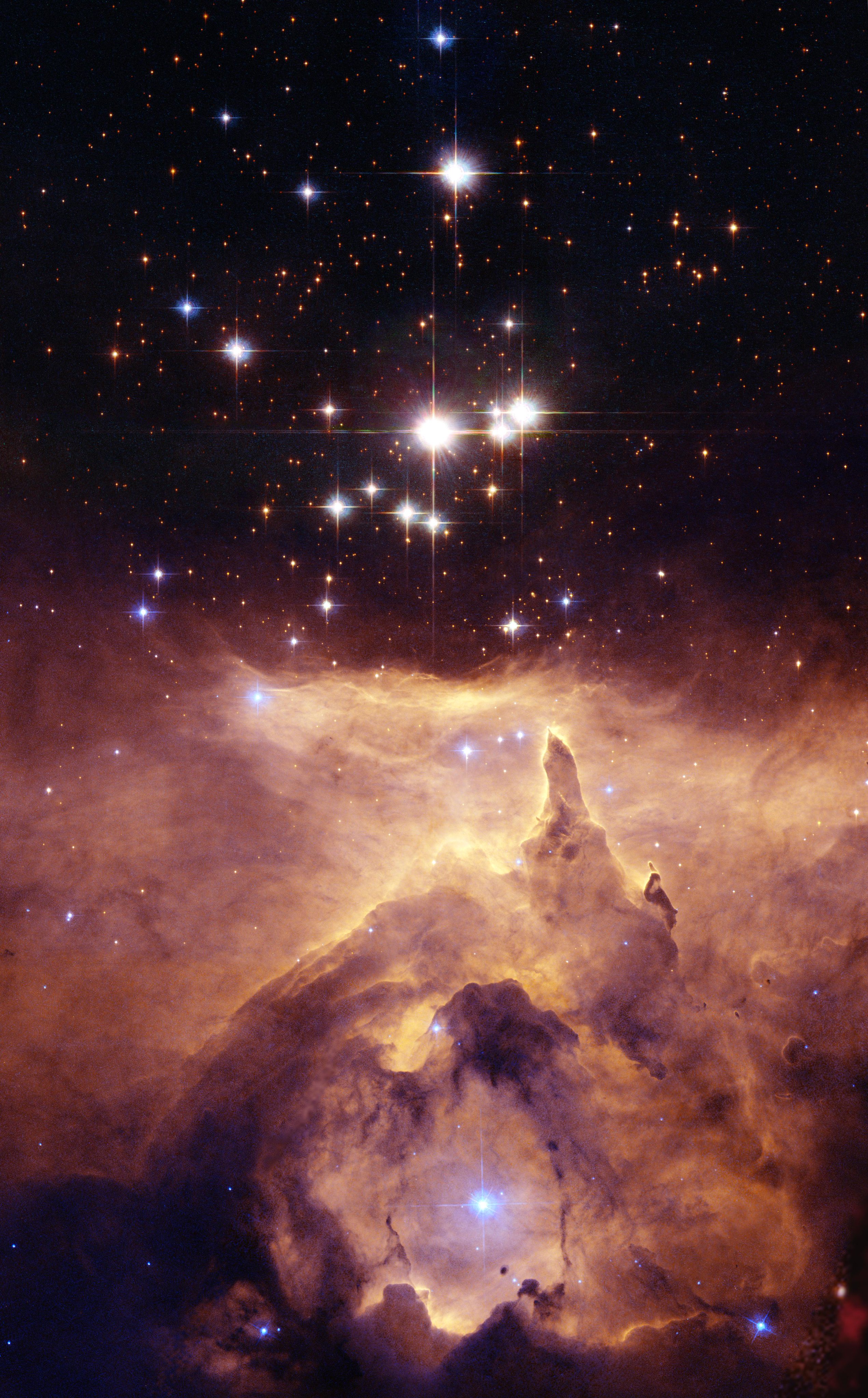 A group of white and blue stars sparkles in the darkness of space. In the background are orange galaxies, sprinkled all over. Below the stars, orange and yellow clouds of gas glow, revealing structures that look like rock formations and arches. Credit: NASA, ESA, and Jesús Maíz Apellániz (Instituto de Astrofísica de Andalucía, Spain); Acknowledgment: Davide De Martin (ESA/Hubble)