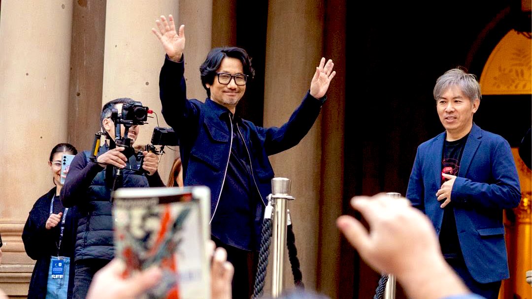 Hideo Kojima aclamado en Sydney en pleno 2025. Mientras tanto, alguien alza su copia (física) de MGS2 Sons of Liberty del año 2001. Definición gráfica de LEGADO <a href="/Kojima_Hideo/">小島秀夫</a>
