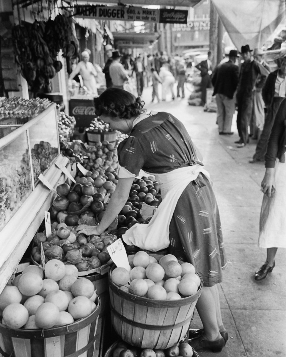 A woman stocks produce in Waco, 1939.  Take a look at the price of grapefruit: 4 for 5 cents. As much as I like her and what she's doing, I like the people in the background almost as much. They seem to be pretty curious re: what photographer Russell Lee was doing. A really super