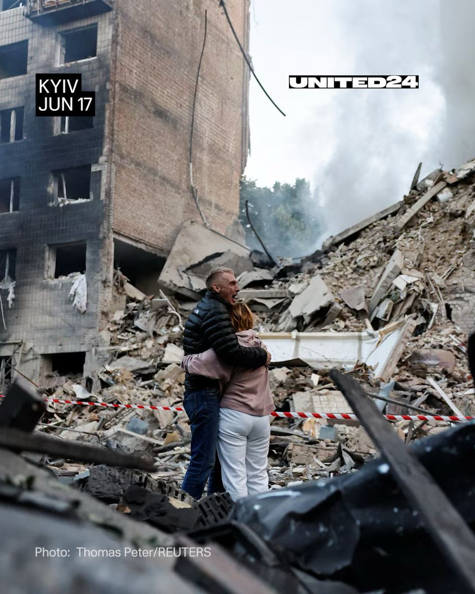 💔 A couple stands before the shattered remains of their apartment building.

Their son is still buried beneath the rubble.