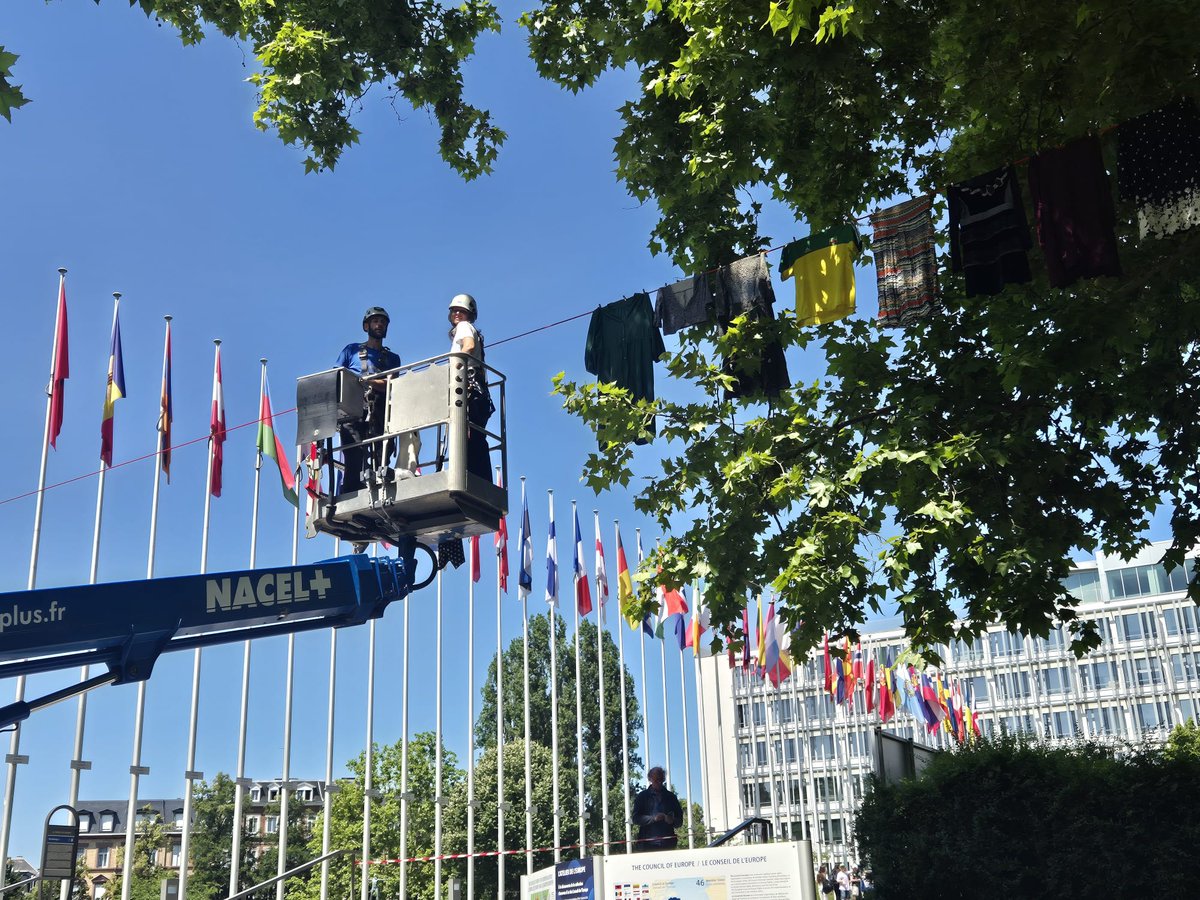 Happening now just outside <a href="/coe/">Council of Europe</a>: Alketa Xhafa-Mripa begins hanging dresses for #ThinkingofYou — a haunting tribute to survivors of wartime sexual violence. Each dress rising to break the silence, to honor courage, &amp; to reclaim dignity of survivors. Official launch in a few days!