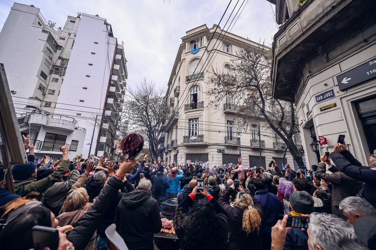 Cristina sale al balcón y saluda a la pueblada que desborda la calle. Lanza besos, sonrisas, agradecimientos. Pero sus gestos no son solo para quienes agitan banderas desde abajo. También dedica saludos a sus vecinos y vecinas que se asoman desde los balcones cercanos.