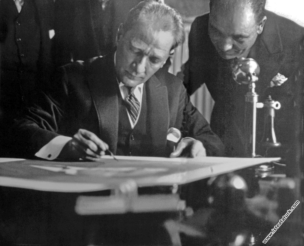 Mustafa Kemal Atatürk, Türkiye İş Bankası'nın Yeni Cami Şubesi'ni ziyareti sırasında, şubeye asılacak fotoğraflarını imzalarken  (16 Haziran 1928)