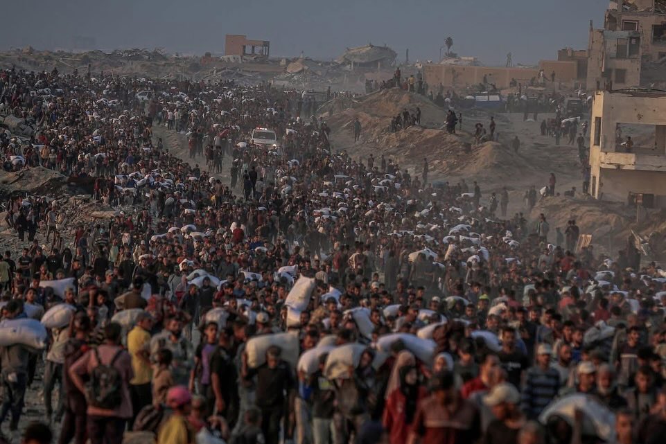 EyeonPalestine's tweet photo. Between those carrying sacks of flour and others bearing the bodies of loved ones, Gaza’s tragedy is captured in a single image — a stark reflection of relentless aggression and deepening famine. https://t.co/uFPusg9TwI