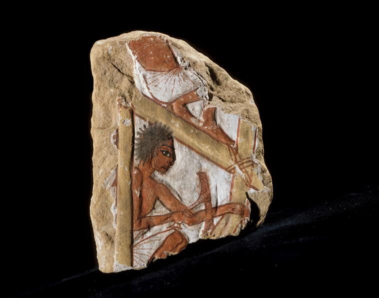 A carpenter at work on a scaffolding

The image depicts a carpenter sitting on a piece of scaffolding or a workbench, using an adze (a tool similar to an axe) to shape wood. Unlike the more common representations of gods, kings, or idealized figures in ancient Egyptian art, this