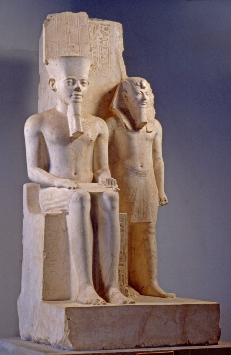 King Horemheb stood beside the enthroned god Amun

▫ Carved from pale limestone and towering just over two metres high (Egyptian Museum, Turin, Cat. 768), this late-18th-Dynasty group statue from Thebes presents king Horemheb standing deferentially beside the enthroned god Amun.