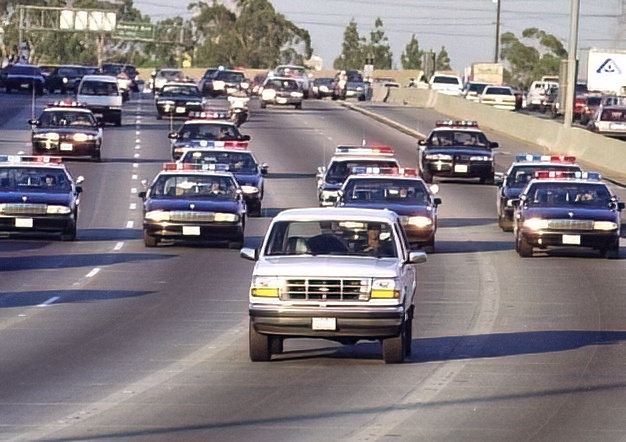 thevidgoo's tweet image. June 17, 1994. OJ cowering in the back of the truck and being escorted by police. It was not a chase.