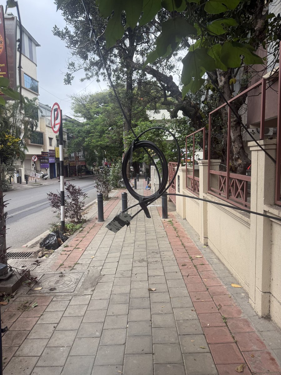Madhuricsa's tweet photo. Wires hanging precariously on the foot path in Malleswaram, 17th cross Margosa road. Nobody has bothered to come and fix it properly since two weeks. Is this what we pay our taxes for?? Such horrible infrastructure @BBMPofficial @NammaBESCOM @BbmpchdTeam https://t.co/lbMW9t9UaU