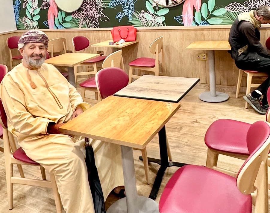 AlsiyabiHamood's tweet photo. في مستشفى "سانت طومس" بلندن "أطلب  فطور اثنين "لي ولأحزاني"   
——————————
 حمود بن سالم السيابي 
——————————
 أتذكرين غالبتي ذات هجعة من الألم أفاقَتْ فيها "ابنتكِ" من المخدِّر الذي غيّبها لساعات وفصلها عمَّا يدور حولها ، فعادتْ إليكِ الروح. 
كانت "ابنتكِ" هي الراقدة على سرير الشفاء في مستشفى "سانت طوماس" بلندن وكنتِ أنتِ المريضة المتكوِّمة على الرخام البارد لغرفة الدور السابع. 
وكلما انهمكتْ الممرضات في التفتيش عن وريد في ظاهر يد "ابنتكِ" لتوصيل الإبرة المغذية كنتِ تلمسين جنبكِ وكأنَّ الإبرة الوريدية انغرزت في كبدك ، لا في وريد "ابنتكِ"
وكانت "ابنتكِ" تكتمُ وجعها لكيلا ينفطر قلبكِ ، وكنتِ الصدى القوي لصوت الوجع لتحشدي المستشفى كله حول سريرها.  
وفيما "ابنتكِ" تستردّ بلُطْفٍ من الله عافيتها تدريجيا ف"العافية بالمثاقيل" كما نقول في دارجتنا العمانية ، كنتِ على تَوتُّركِ المقلق تساهرين أنين الأضلع وثورة المفاصل واحمرار المقل التي تخثر فيها البكاء. 
وكان ضغطك قد دق أجراس الخطر لنزوله لما تحت المعدل ، وأضاءَ كل اللمبات الحمراء لارتفاعه بدرجات مرعبة لما فوق المعدَّل. 
 وظل ضغط دمكِ على اضطرابه فلم يستقر إلا بعد أن ابتسم الطبيب المعالج في بشارة منه بنجاح العملية.  
يومها صَغَرْتِ خمسين عاما ، وكنت قبل ابتسامة الطبيب بدقائق تهيلين ركام مائة عام على وجهك الشريف. 
أتذكرين غاليتي توسلي لعينيكِ بأنْ ننزل للمطعم للقيمات تسدين بها رمقكِ وتقيمين بها أوَدَكِ ، وكنت تقدمين خطوة مرتعشة وتتراجعين ثلاث خطوات مكابرات.  
ولعلِّي أسأتُ الأدب مضطراً حين فقدتُ السيطرة على شعوري دون وعي وأنا أجبركِ على تركِ "ابنتكِ" لدقائق يتاح فيها لضجيعة مستشفى "سانت طوماس" بأنْ تنام قليلا فيأخذ المخدر مساحته. 
ساعتها تسحَّبنا إلى الدور الأرضي الصاخب بالمحال والمقاهي والمطاعم. 
وكان مصعد المستشفي بطيئاً كتثاقل الوقت في عينيكِ وكئيبا كسماء لندن ومهموما بالموجوعين مثلنا. 
وكلما توقف المصعد عند طابق من الطوابق ازدادتْ قبضة يدك على طرف "الغدفة" ليندسَّ وجهك الشريف عن الذين ازدحم بهم المطعم.   
وحين جئتكِ بصحن عليه ما توفَّر من أطباق يبيعها مطبخ المستشفى ، كنتُ على يقين من أن أطراف أصابعكِ وحدها ستلمس ما على الطبق ولن تسيح لكِ لقمة قبل أن تكون "ابنتكِ" قبالتكِ ولها نفس الطبق. 
هذا هو مطعم مستشفى "سانت طوماس" غاليتي على حاله رغم تقادم الحدث. 
وهذا كرسيك الخشبي بكسائه الأحمر مكانه على كثرة من جلسوا عليه. 
أعود غاليتي لنفس المستشفى وأوشكُ أن "أطلب فطور اثنين" كما فعل بصير اليمن البردوني ، وإن "قالوا بأنني وحيد فقلت اثنين، إن معي" أنتِ. 
وكما كنتِ تترددين للنزول من جوار سرير الطابق السابع رغم ابتسامة الطبيب ، هأنذا أتردد عن الكتابة عن المستشفى الذي يحمل اسم "توماس بيكيت والقادم من القرن الثاني عشر وبالتحديد عام ١١٧٣م. والمتموضع قبالة "وستمينيستر" حيث ترن خلف مراياه ساعة "بج بن" ويتماوج نهر التايمز والتاريخ.
أقر غاليتي أنني لا أجد شهية التطواف بمرافقه وتقليب ملفاته وأسماء مشاهير مرضاه من الملكة إليزابيث الثانية إلى رؤساء وزرارات بريطانيا العظمي وآخرهم الرئيس بوريس جونسون.
إلى جانب تجذره في الحياة الثقافية حيث طبعت من نفس مقره الحالي أول نسخة إنجليزية للإنجيل. 
وكتبت في غرفه أغنية "غروب الشمس في واترلو".  
كما دخلت مبانيه وأقسامه العلاجية الذاكرة السينمائية في فيلم "لاست أوردرز" المأخوذ عن رواية البريطاني جراهام سويفت بنفس العنوان والفائز بجائزة البوكر عام ١٩٩٦م. 
وتكرر الأمر بفيلم الرعب الذي حمل عنوان "بعد ٢٨ يوما" لأليكس جاردن. 
ماذا سأكتب عنه غاليتي فابنتك لوحدها ستقرأ هذه السطور ولن تقرأها لكِ. 
وستستذكر الصور ولن تريكِ إياها. 
وكنت أتحسَّر على سوء أدبي معكِ وأنا أرفع صوتي في وجهك بالطلب لتأكلي فأقول مجددا ليتني أقل أدبي اليوم وألزمكِ النزول لمطعم المستشفى لتجلسي على نفس الكرسي لتتلمسي بأطراف أصابعك طعاماً لن يسيح. 
—————————
لندن في ١٨ يونيو ٢٠٢٥م.