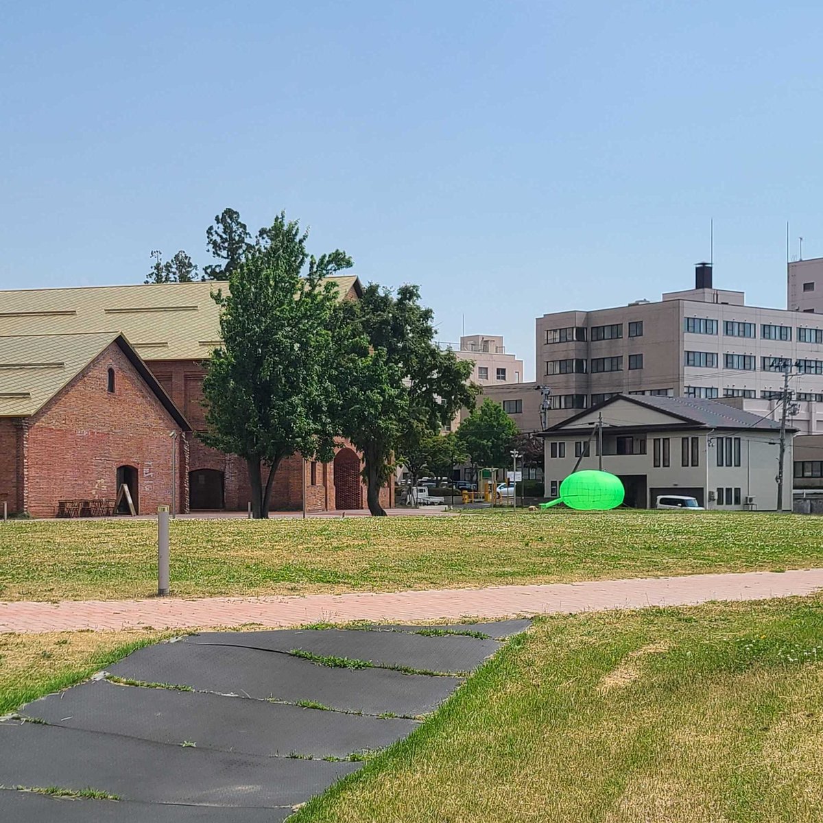 少し遠くからの眺め🟢 

#さとうりさ による作品は、7/11〜13開催の #れんがひろばのアートフェス 中、屋外で複数展示するほか、ワークショップも開催します。お楽しみに！

✔️れんがひろばのアートフェス詳細
hirosaki-moca.jp/events/10980/