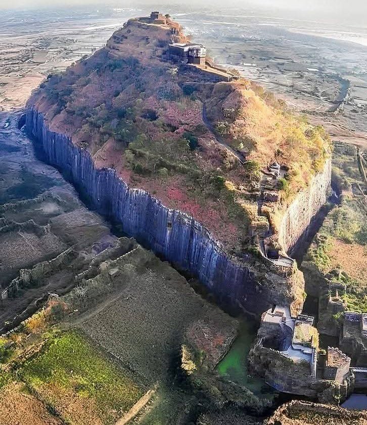 Daulatabad Fort, located in Maharashtra, India 🇮🇳, originally built in the 12th Century CE by the Yadava dynasty and later fortified by successive dynasties, including the Delhi Sultanate and the Mughals. The fort stands atop a conical hill of volcanic origin, providing natural