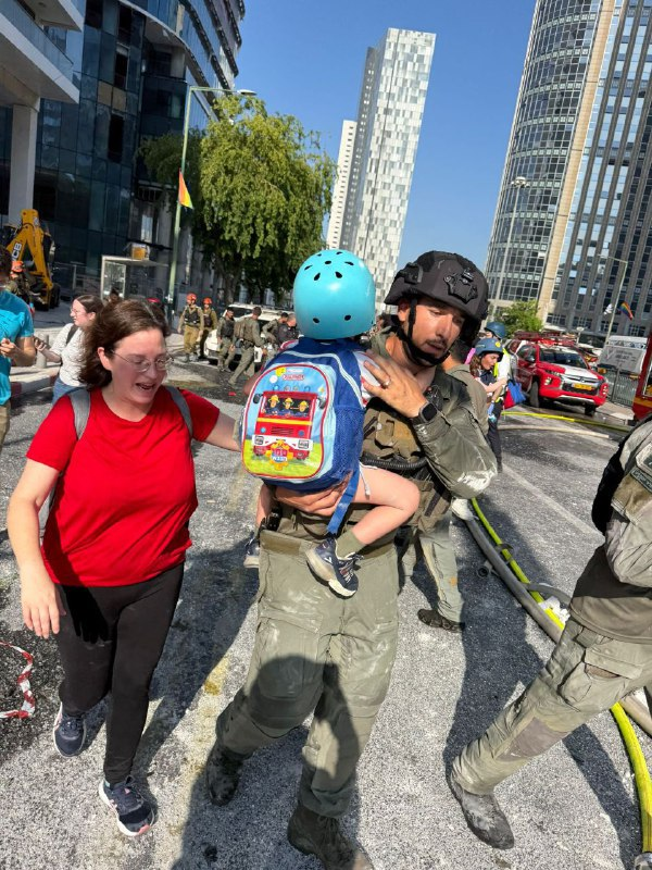 elikowaz's tweet photo. An IDF officer rescues a small child from one of the impact sites in central Israel https://t.co/cwxEZsFCJQ