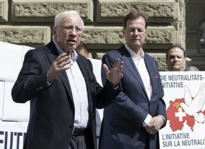 Blocher wird von einem Trump-Wähler assistiert. So geht Neutralität à la SVP. Der Rest der Anwesenden sind übrigens Putin-Boys.