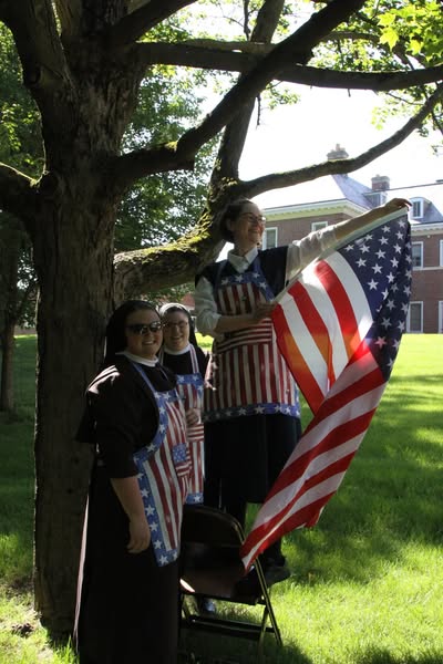 NunsHolding's tweet image. A Religious Sister of the Sisters of St. Francis of Perpetual Adoration in Mishawaka, Indiana hanging up an American flag. Photo from the Sisters' Facebook page at facebook.com/ssfpavocations….
