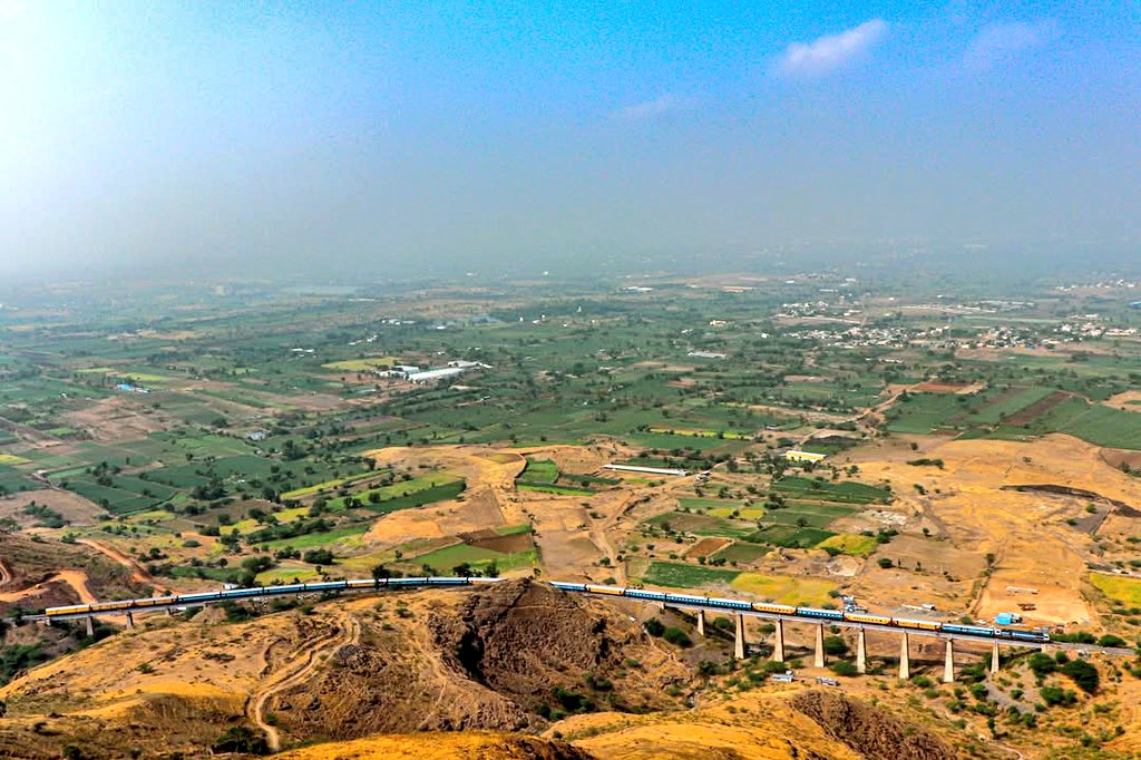 This is a beautiful picture captured from the Dhavaleshwar temple of a train passing over the long viaduct in the Shindawane Ghats on the Pune-Satara line, in the jurisdiction of <a href="/drmpune/">DRM Pune</a> in <a href="/Central_Railway/">Central Railway</a>! Pic courtesy, Pranit Gawand! #IndianRailways #photography <a href="/docbhooshan/">Bhooshan Shukla</a>