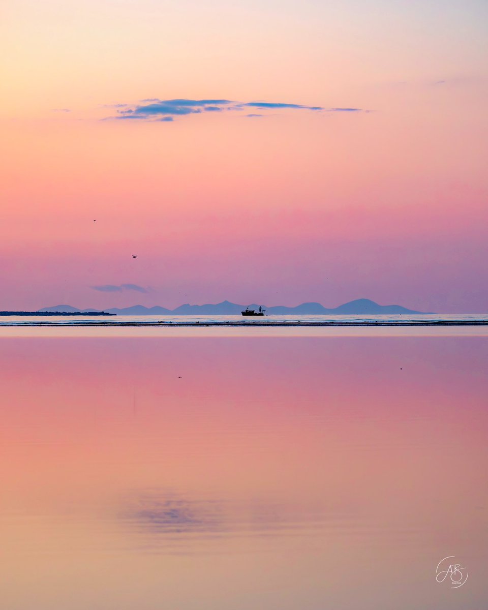What a beautiful evening on Burrow Beach yesterday. A fishing boat drifted past the distant silhouettes of the Mourne &amp; Cooley Mountains, as Dublin Bay lay bathed in breathtaking sunset hues. The calm water  mirrored the sky as nature provided another ‘in awe’ moment.