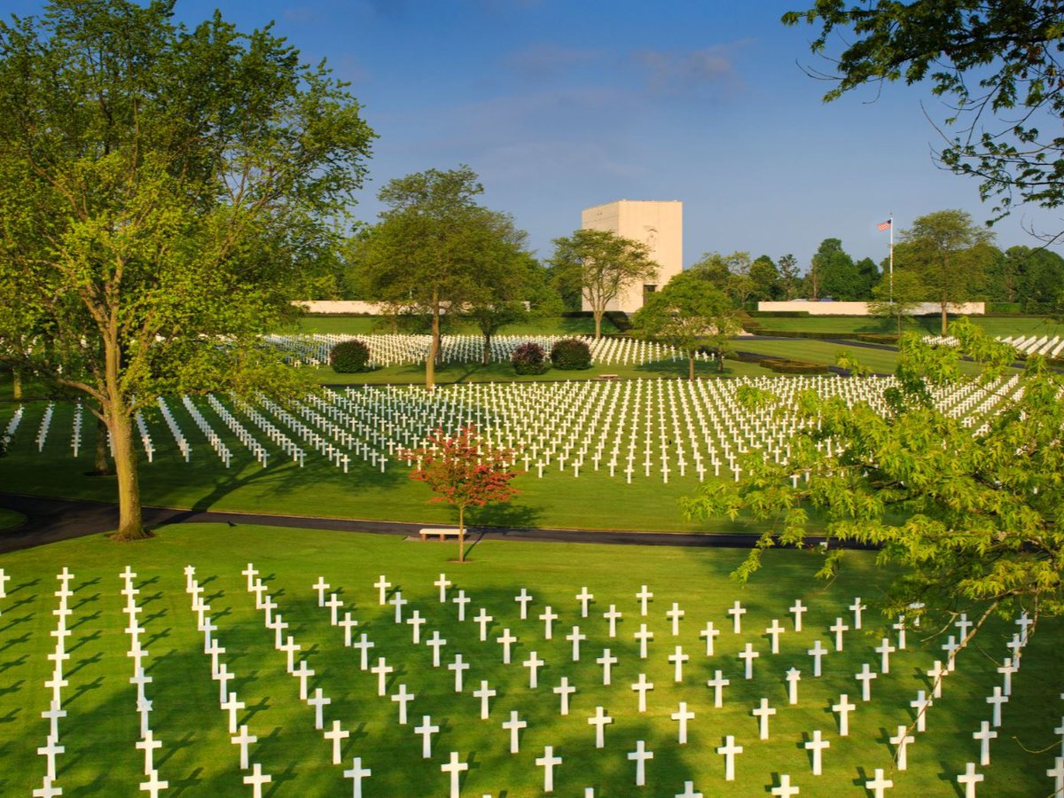 Can you name this World War II American military cemetery?

◽ This Cemetery contains the largest number of graves of our military dead of World War II in Europe, more than 10,000 in total. 

◽Most of the military fallen interred and memorialized here were killed while driving