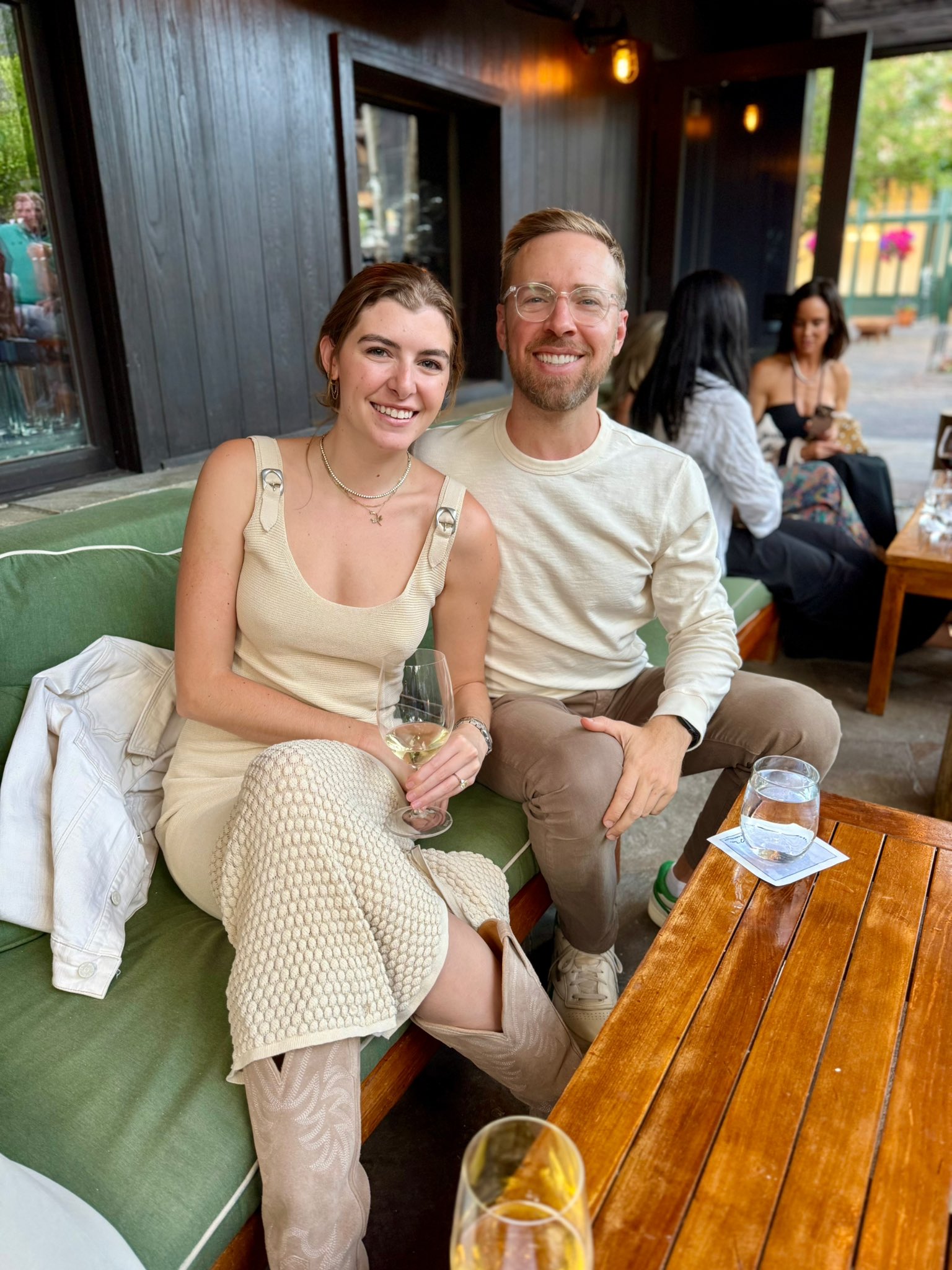 A man and woman sitting together while holding a glass of wine.