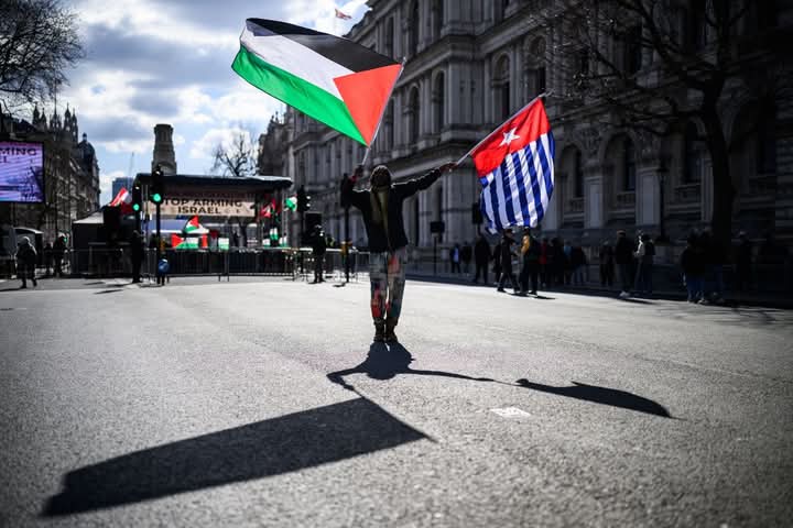 tewewulin's tweet photo. Seorang pria mengibarkan bendera Palestina (kiri) dan Bintang Kejora (kanan) menjelang unjuk rasa di akhir Pawai Nasional untuk Palestina, pada 15 Maret 2025 di London. Copyright Leon Neal/Getty https://t.co/UBEeDdeNmp https://t.co/ZZhb9SOtyP