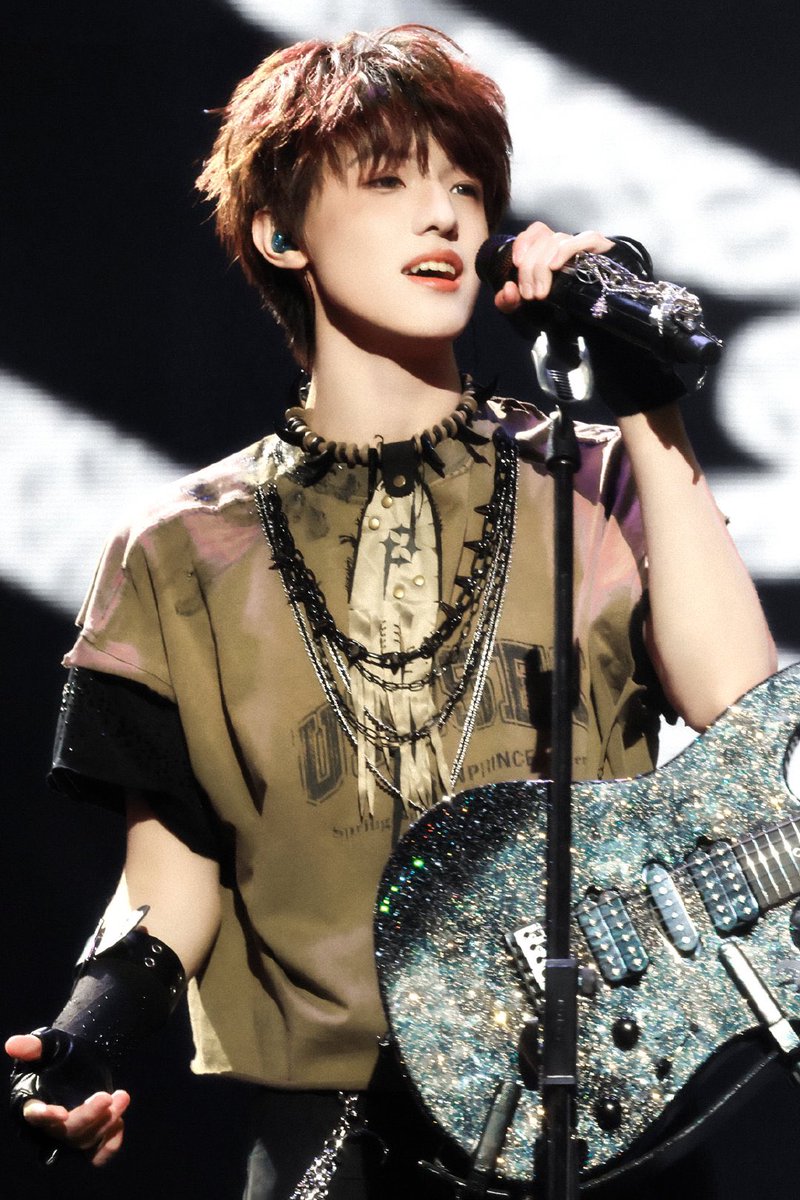 Arika_0323's tweet photo. On stage, he holds a diamond - glistening guitar. Stacked chains sway to the rhythm. When the mic catches his voice, noise and passion ignite. Each note is youth's wild rock bloom.💚

#zhangzeyu张泽禹
#ZhangZeYu 
#张泽禹 https://t.co/Kx1nWaNmM5