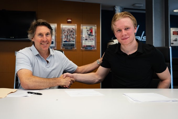 Senior Vice President & Assistant General Manager Don Fishman and Milton Gästrin pose for a photo after the Caps prospect signs his entry-level contract.