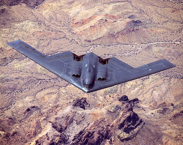 cpt340's tweet photo. Devido à ausência de uma cauda convencional com estabilizadores vertical e horizontal o bombardeiro B2 é um avião inerentemente instável do ponto de vista aerodinâmico. Só com recurso aos quatro sistemas FBW Fly by Wire que controlam os comandos de voo realizando centenas de operações por segundo é possivel assegurar a estabilidade desta "asa voadora", nome por que é conhecido este conceito. Os quatro motores "ajudam" no controle direcional com recurso a potência (impulso) assimétrica. É impossível este avião ser pilotado manualmente por um humano; o design não contempla essa possibilidade porque ninguém teria a capacidade de reação suficiente para fazer as correções necessárias em tempo útil. A função do piloto consiste essencialmente em fornecer dados para os sistemas de navegação e gestão de voo; os automatismos fazem o resto.