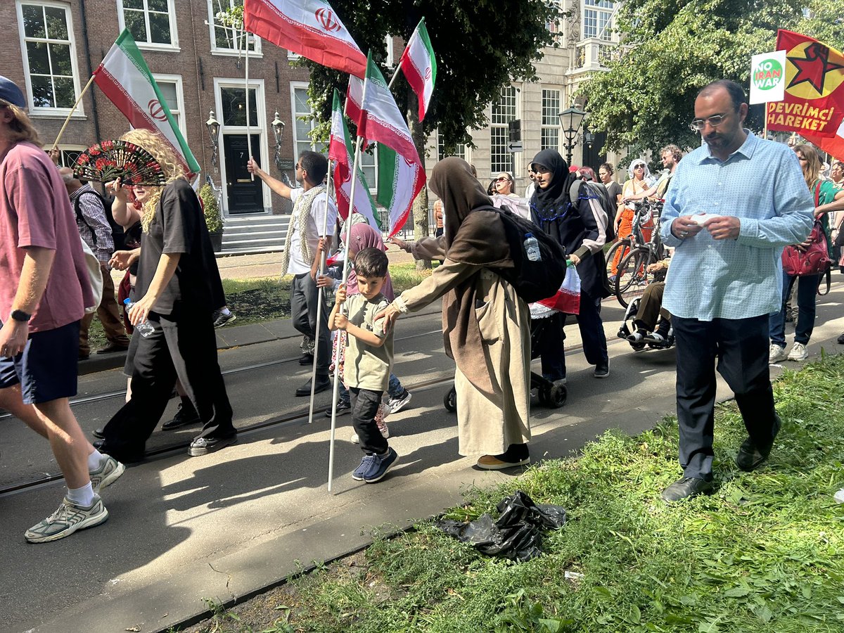 olthof_tom's tweet image. Kinderen dragen de vlag van het Iraanse mullahregime. Hun ouders spreken geen Nederlands en weigeren een reactie.
#navo #DenHaag