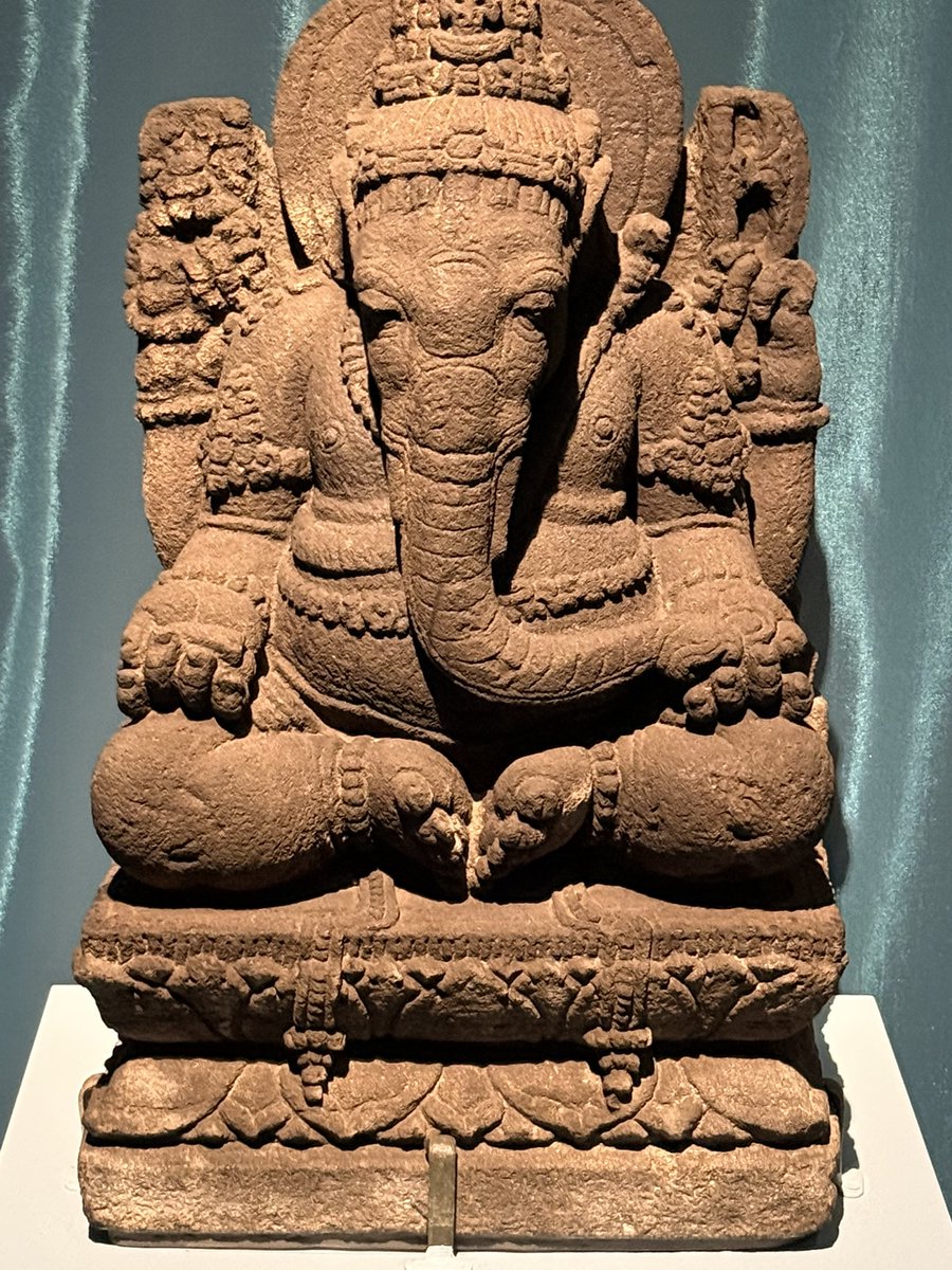 HeraldLinde's tweet photo. The world needs a bit of beauty. Saw this stunning Javanese Ganesha 🐘 at the British Museum's "Ancient India" exhibit 🏛️. Originating c. 1000-1200 CE (Kediri/Singasari?), it sits with feet together, evoking a childlike princess from the *Sumanasantaka* poem. A small skull adorns its head. A beauty.