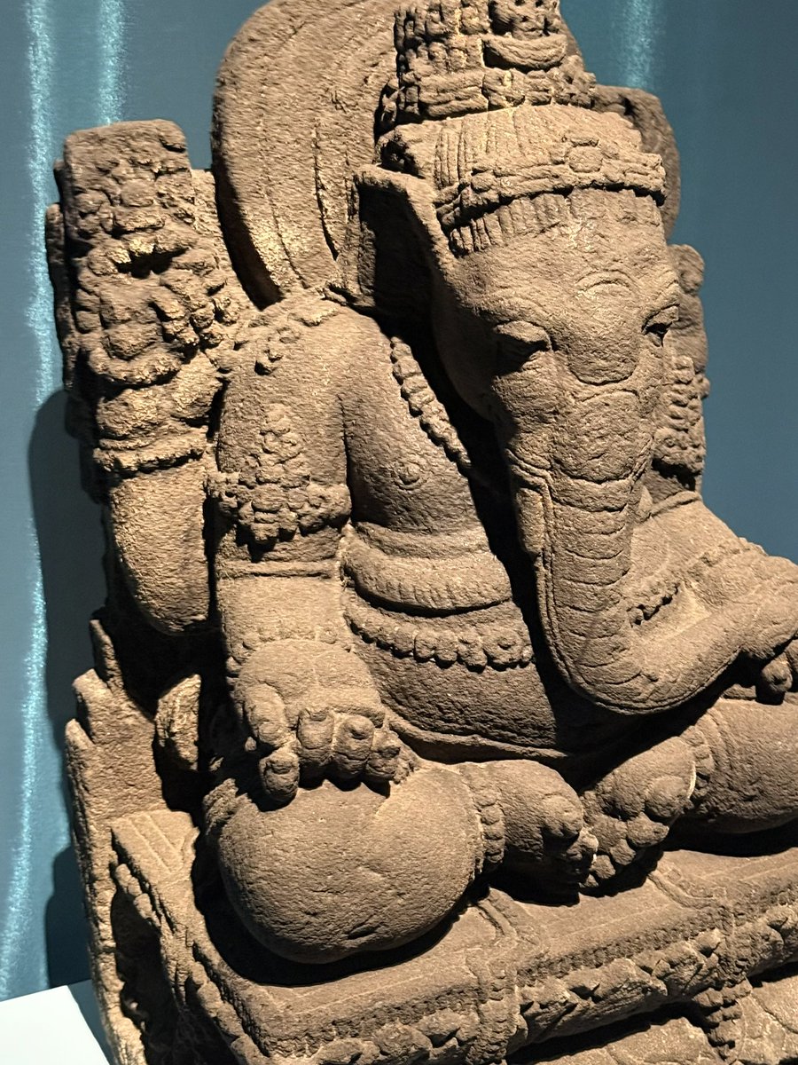 HeraldLinde's tweet photo. The world needs a bit of beauty. Saw this stunning Javanese Ganesha 🐘 at the British Museum's "Ancient India" exhibit 🏛️. Originating c. 1000-1200 CE (Kediri/Singasari?), it sits with feet together, evoking a childlike princess from the *Sumanasantaka* poem. A small skull adorns its head. A beauty.