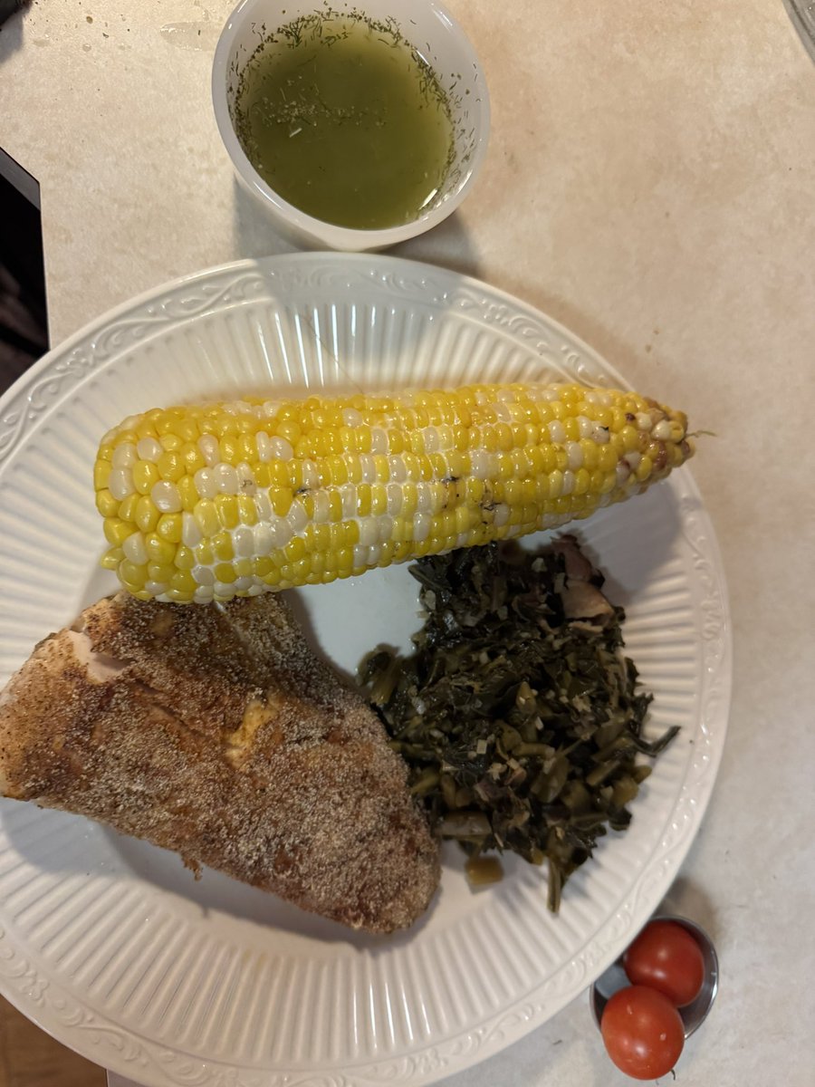 Pan fried fresh Alaskan halibut, with lemon butter sauce, turnip greens seasoned with bacon and ear corn.  Bonus first two cherry tomatoes of the season! #halibut #kbouzercooks
