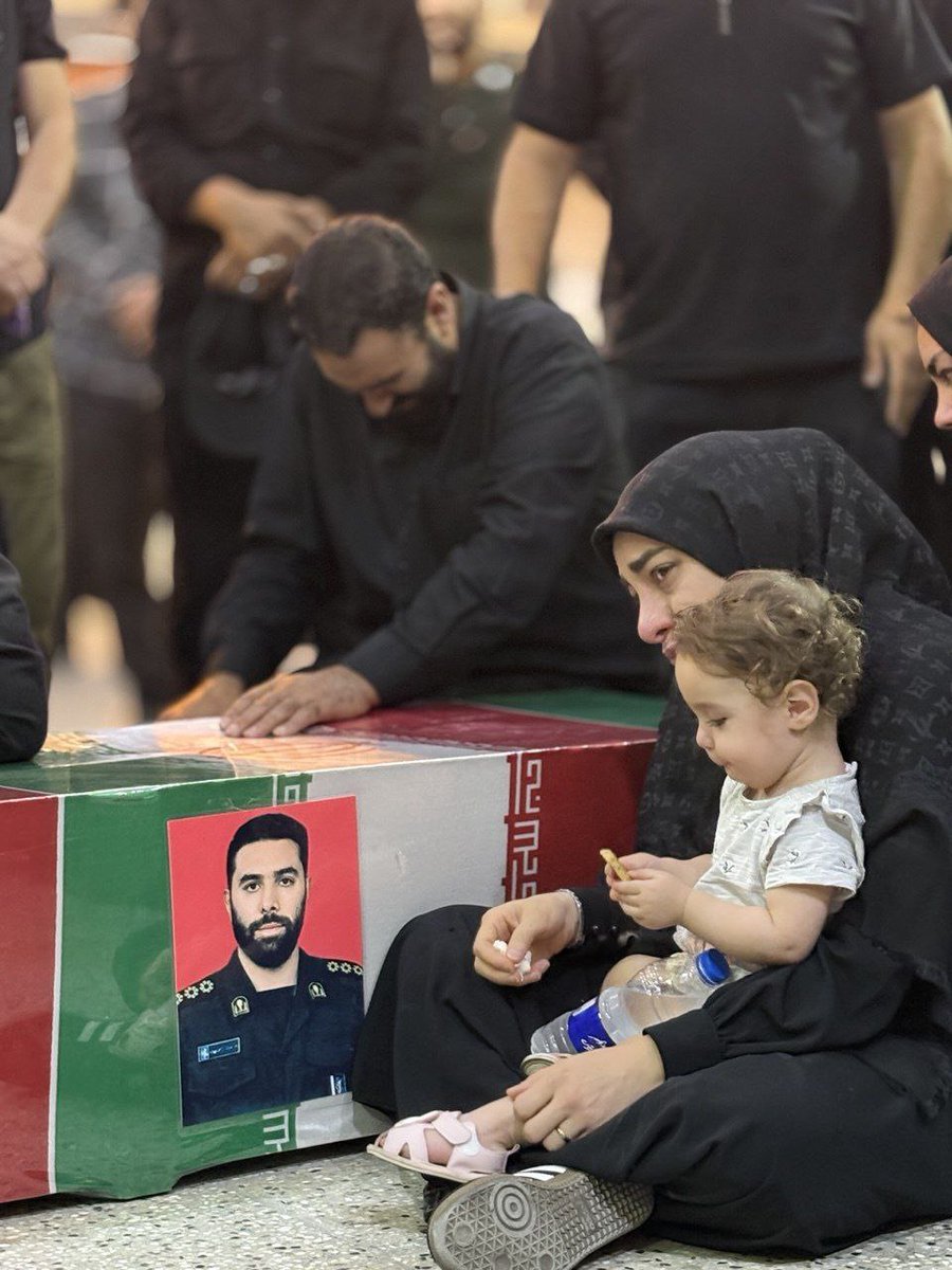 تصویری از همسر و فرزند شهید رامین نصیری در کنار پیکرشهید