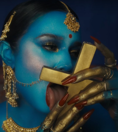 PakshForBharat's tweet photo. 🟥 Tommy Genesis Slammed for Dressing as Goddess Kali & Licking Crucifix in New Music Video

Canadian rapper Genesis Yasmine Mohanraj (aka Tommy Genesis) faces a massive online backlash for her provocative music video True Blue. 

In the clip, she's painted blue with Hindu goddess Kali imagery sparking accusations of cultural appropriation and blasphemy from both Hindu and Christian communities.

#TommyGenesis #CulturalAppropriation #Blasphemy #TrueBlue #ReligiousRespect