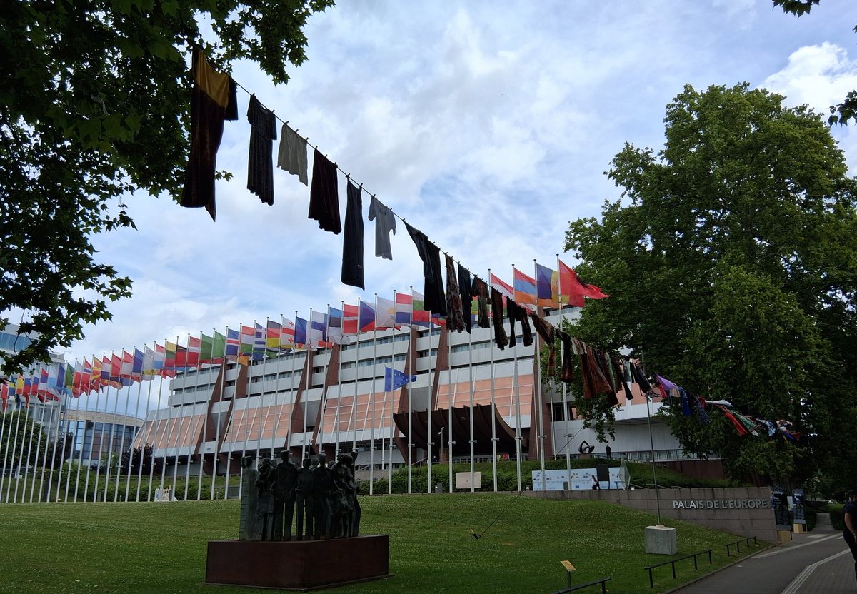 GermanyCoE's tweet photo. Next to the 46 flags of the @Coe member states, skirts and dresses symbolising the victims of sexual violence in conflicts and wars are waving in front of the Palais of Europe. By "thinking of them", by showing their pride, we break the silence they suffer and the guilt they feel https://t.co/anY1ls9vHQ