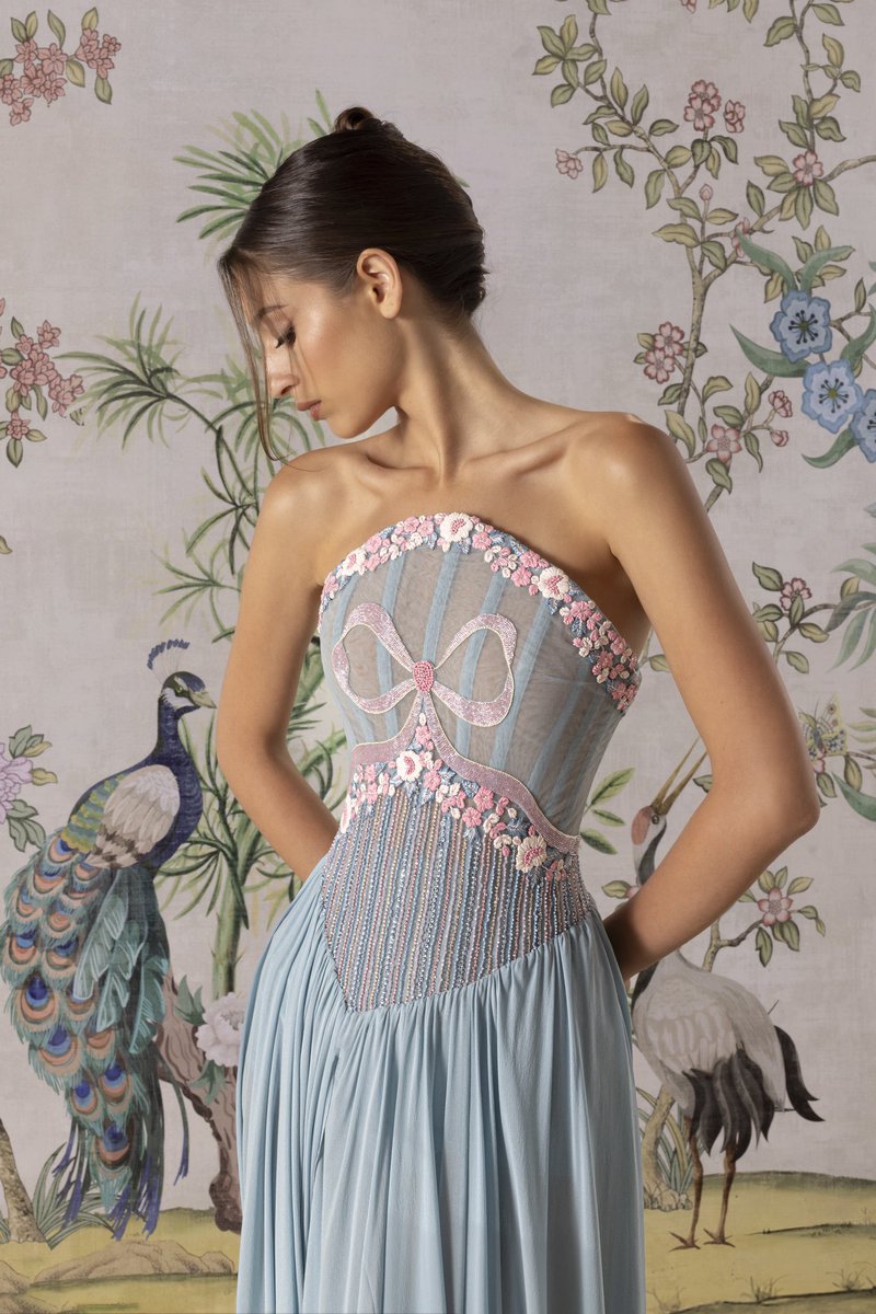 From initial sketch to final silhouette — a stone blue mini #RamiKadiCouture dress featuring a bodice embroidered crystal stones, raffia threads, and beads, with a touch of blush pink - overlaid with a draped muslin skirt.

#RamiKadi #RamiKadiCouture #Cannes2025