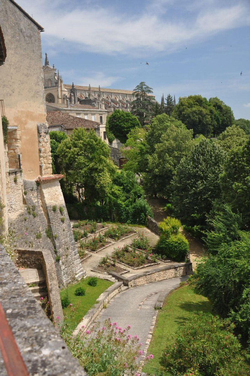NZAllison's tweet photo. Bezas cathedral. Another of those "prettiest villages" which we saw on our way to the Roquefort, that wasn't.
Council offices from the old covered cattle market. View from the ramparts to the Sultan's Garden below. Old utility building being slowly renovated. 
#Bezas https://t.co/ypanaSVb8e