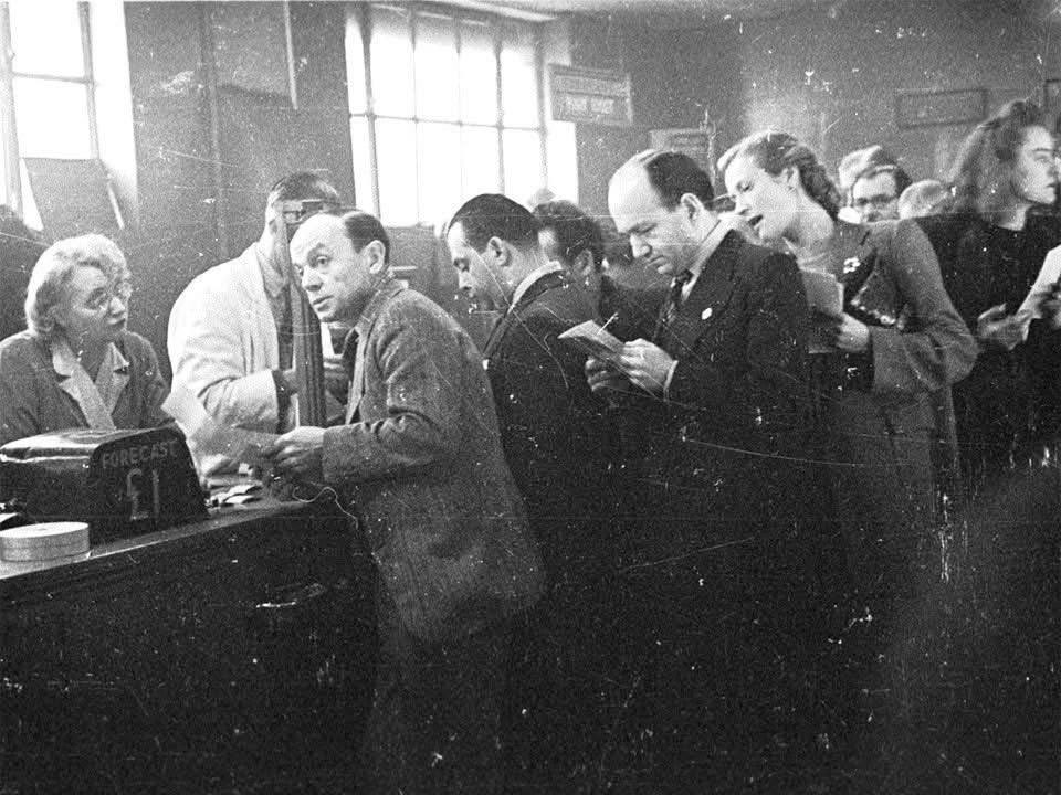Punters line up to place bets the old-fashioned way at London's White City Greyhound Racing Stadium in 1943